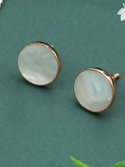 A close-up of the Moonlight Shell stud earrings. The simple, elegant design highlights the natural iridescence of the mother of pearl, framed in warm rose gold.
