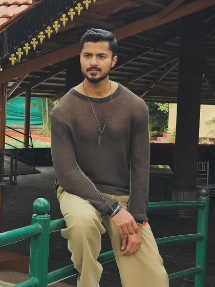 A more serious and thoughtful pose in a casual setting.