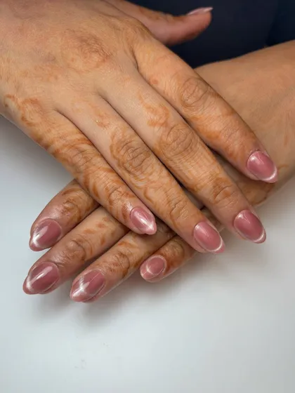 The French cat-eye effect on beautifully manicured hands. The subtle magnetic shimmer catches the light beautifully.