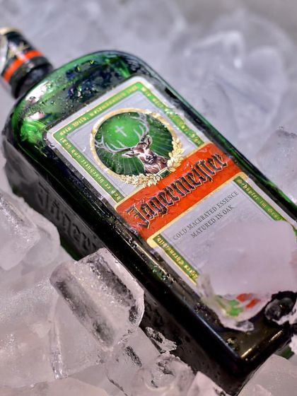 A close-up of a Jägermeister bottle nestled in ice. I ensure that all spirits, especially those best served cold, are kept at the perfect temperature throughout your event.