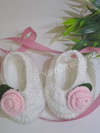 Another look at the white and pink rose booties, showing their delicate and timeless design.