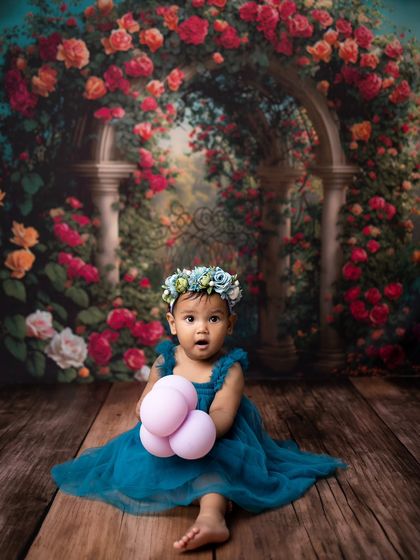 After her bath, she's dressed in a beautiful blue tulle dress with a matching floral crown, looking like a little garden fairy.