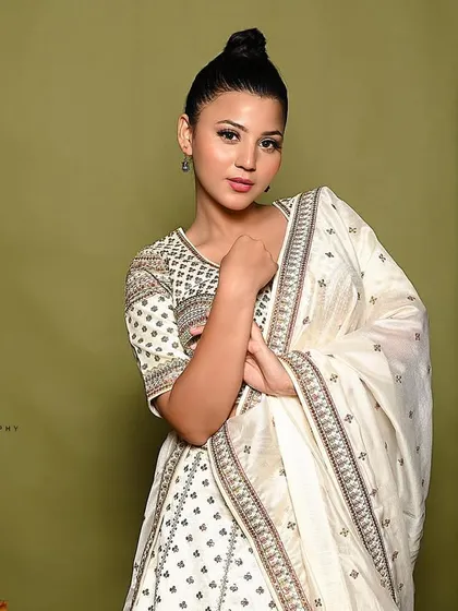 A soft and elegant portrait. The model's pose, gently holding the dupatta, draws attention to the delicate fabric and the overall grace of the outfit.