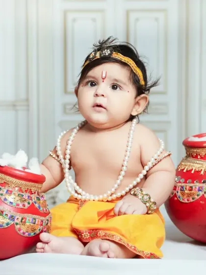 A chubby and adorable baby Krishna poses with his pots of butter. Our sessions are flexible to make sure even the youngest babies are comfortable.