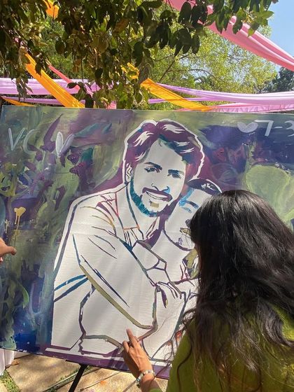 A guest adding the final touches to the couple's portrait. It's a process of layering colors and memories.