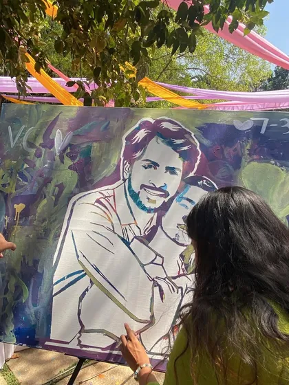 A guest adding the final touches to the couple's portrait. It's a process of layering colors and memories.