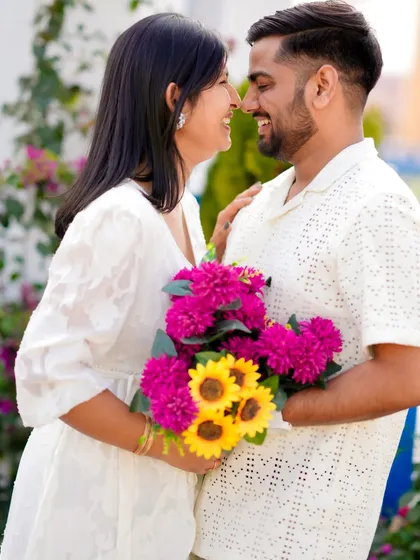 A sweet kiss on the cheek captures the affection and happiness of this couple. Set against a simple, colorful backdrop, this candid shot is all about their natural chemistry.