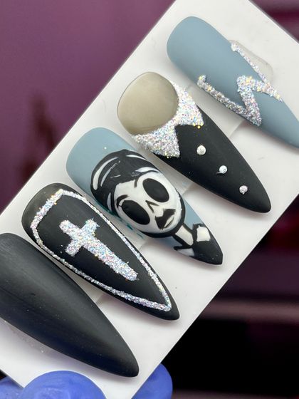 Getting into the spooky spirit with this hand-painted Halloween set, featuring a skeleton character, a coffin, and glittery accents.