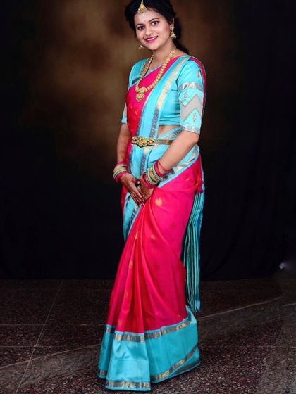 Our client Archana radiates elegance in this gorgeous silk saree, featuring a striking contrast of pink and blue.