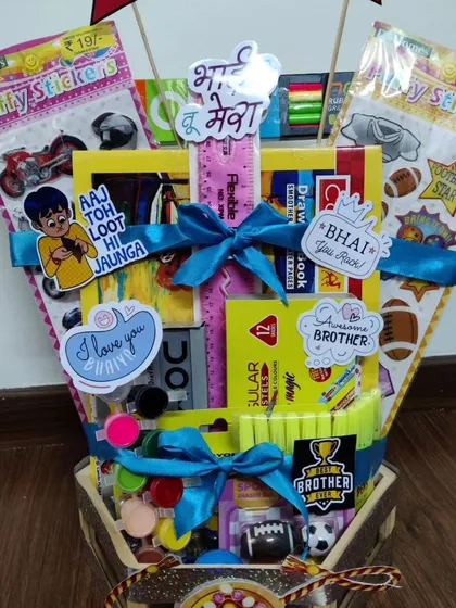 Here is a closer look at the stationery-filled Rakhi hamper for kids. You can see the variety of items included, from paints and stickers to a drawing book, offering a creative alternative to traditional snack baskets.