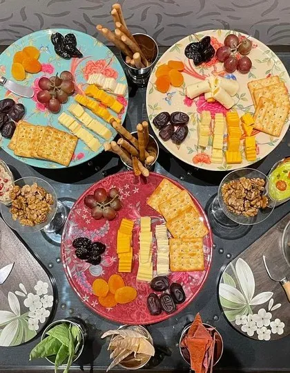 An overhead view of one of our signature grazing tables. We artfully arrange a variety of artisanal cheeses, cured meats, fresh fruits, nuts, and crackers to create a feast for the eyes and the palate. It's a perfect, informal way for guests to mingle and enjoy.