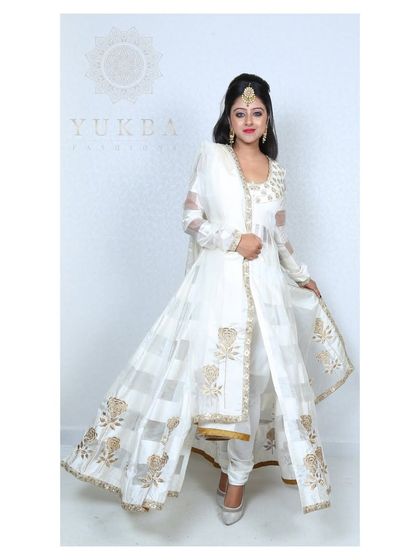 The model showcasing the flow and movement of the white front-slit Anarkali gown.