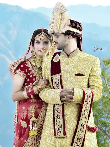 A classic pose that showcases the couple's coordinated wedding outfits. The bride's look towards the groom adds a touch of romance.