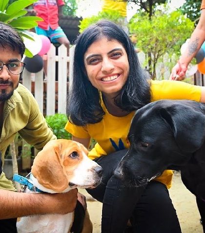 A happy group photo with a beagle and a black lab mix. Our cafe brings people and their pets together.
