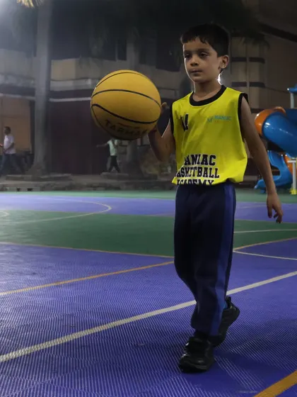 A young player walks confidently with the ball. This is a snapshot from our February sessions, showing the progress and focus of our youngest Maniacs.