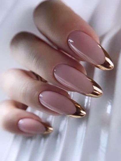 Here is another take on the metallic French tip, this time on a classic almond shape. The shiny gold chrome provides a beautiful contrast against the soft, natural-looking base, offering a touch of modern glamour.