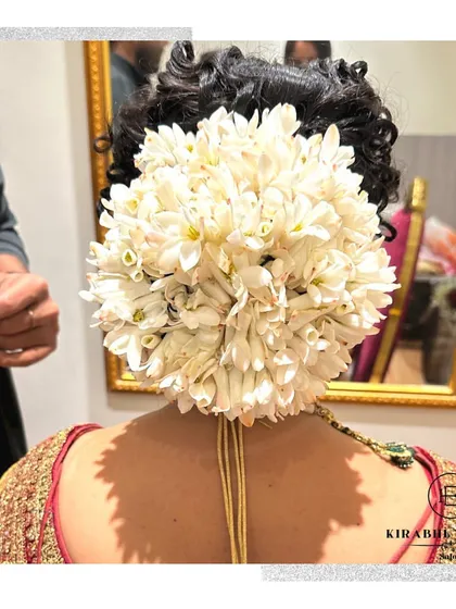 A close-up of a gajra bun, a traditional bridal hairstyle using fresh jasmine flowers. The fragrance and beauty of the flowers add a special touch to the look.