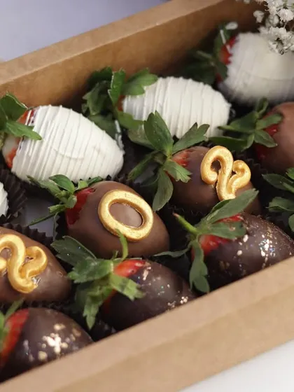 A box of chocolate-dipped strawberries, specially decorated with golden numbers to celebrate the arrival of 2025. This is a sweet and celebratory treat for your New Year's Eve countdown.
