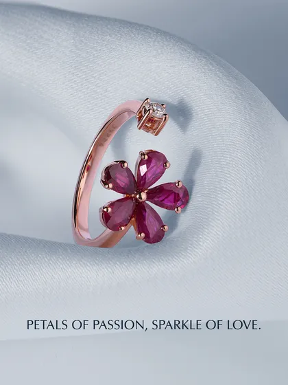Petals of passion, sparkle of love. This open ring design features a flower made of pear-shaped rubies, with a single brilliant diamond at the opposite end. The rose gold setting enhances the warmth and romance of the piece.