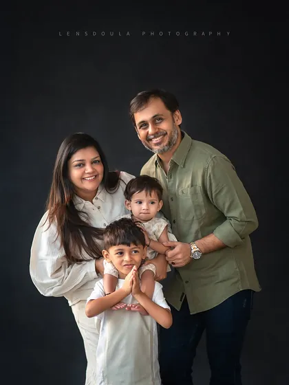 A lovely family of four portrait, with the older brother proudly holding his little sister. These are the moments that truly define a family's love story.