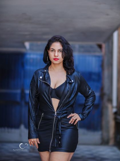 Using the shadows and depth of an alley to frame the subject. Her direct gaze is powerful, and the contrast between light and shadow adds a cinematic feel.