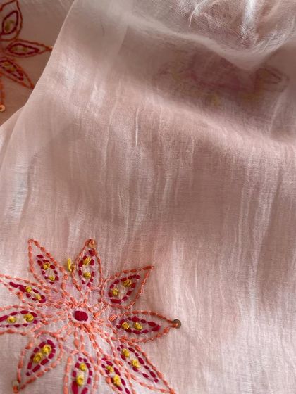 This hand-embroidered Mul Chanderi features delicate floral medallions in warm, earthy tones. It's a fabric that tells a story of artisanal craftsmanship.