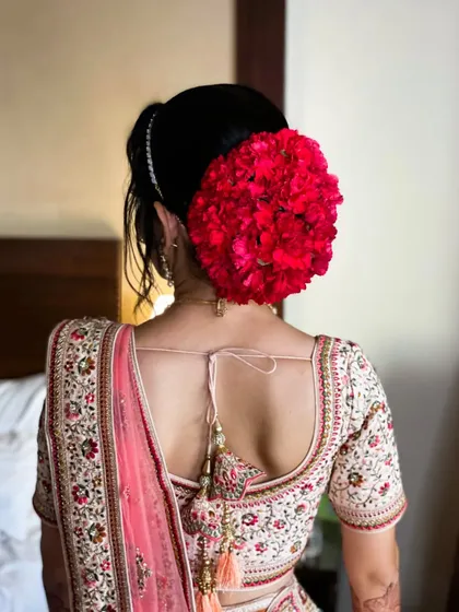 A classic floral bun for a wedding day. I used these vibrant red flowers to create a look that is bold, traditional, and absolutely stunning.