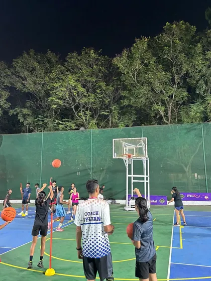 A view of our coach leading a shooting drill during an evening session. Our courts are well-lit for night training.