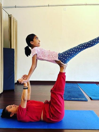 Acro on the menu. A simple and sweet 'throne' pose with a young student. Acro Yoga is for all ages.