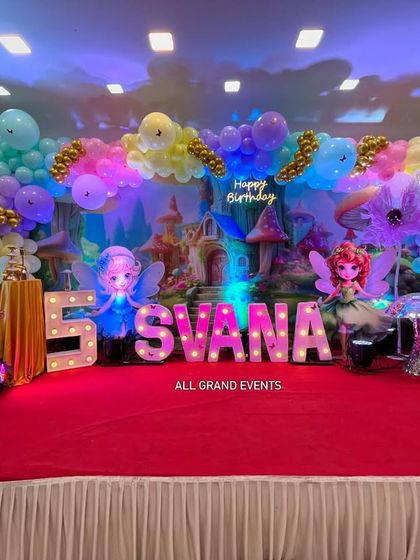 This wide shot shows the entire stage on a red carpet, ready for the birthday girl's grand celebration.