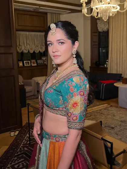 A close-up of the multi-colored lehenga look. This angle shows the beautiful details of the blouse and the way the makeup enhances her features without competing with the outfit.