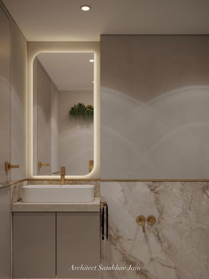 A serene blend of warm beige tones, marble textures, and soft lighting creates a calming spa-like atmosphere in this bathroom. A floating vanity, wall-mounted WC, and brushed gold fixtures add sophistication, while the backlit mirror brings depth and elegance.