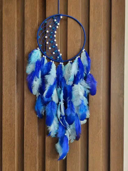 Believe in the magic of your dreams. This mystical moon-shaped dreamcatcher in shades of blue is a beautiful symbol to hang in your room for peaceful nights.