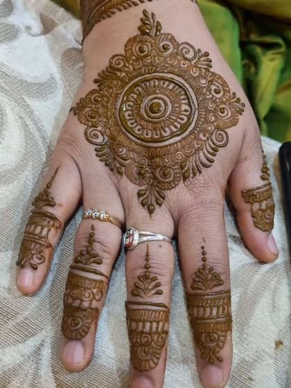 A simple and elegant mandala for a party guest. The design is focused on the back of the hand with minimal, delicate details on the fingers.