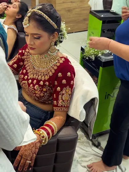 A close-up of our team working on the bride while she is still in her prep clothes. This shows the detailed work that goes into creating the foundation for the final look.
