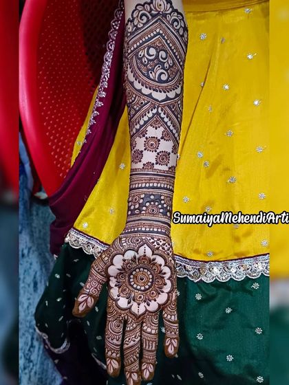 This bridal design features a large, beautiful mandala on the palm. The arm is decorated with bands of different traditional patterns, creating a very regal and elegant look.