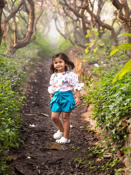 The world is a better place with a child's love and laughter. Walking down this green path, she looks so happy and free, a perfect memory from her birthday celebration.