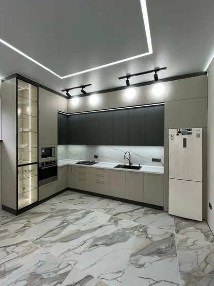 A showcase of our modern kitchen designs, this space combines functionality with sleek aesthetics. We used a dual-tone scheme with matte black and beige cabinets, a marble-patterned backsplash, and integrated profile lighting for a clean, contemporary look.