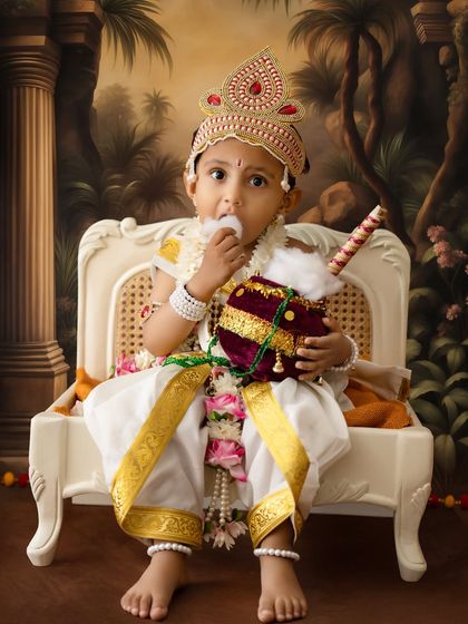 This little Krishna is caught enjoying some "butter" from his matki. It's a fun, candid-style shot that captures the playful spirit of the festival.