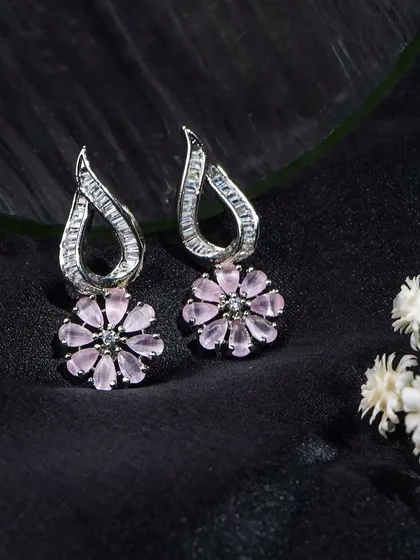 Another angle of these beautiful floral earrings, styled with delicate white flowers. This adds a soft, natural element to the product shot.
