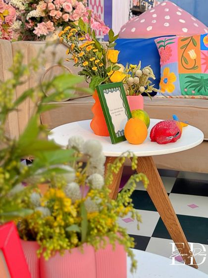 A close-up of a table setting, focusing on the mix of fresh flowers, fruits, and custom-framed messages that personalize the space.