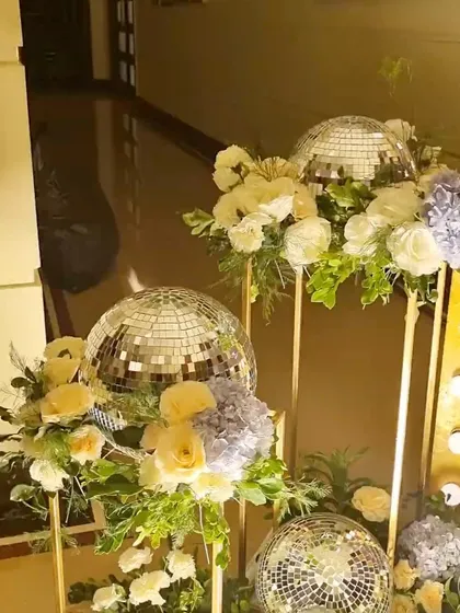 A detail shot of the floral and disco ball arrangements at the Sangeet entrance. The combination of reflective surfaces and fresh flowers created a dynamic and festive welcome for guests.