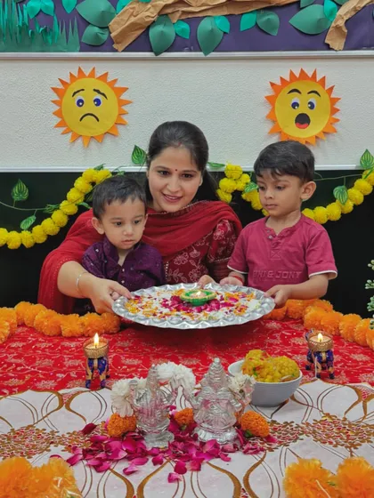A teacher and two children with a decorated thali for Diwali. We ensure our celebrations are interactive and hands-on for the little ones.