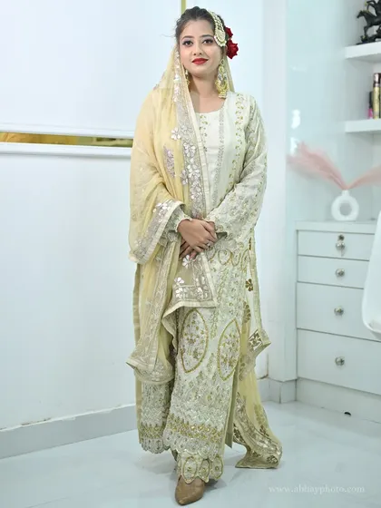 A full-length view of the elegant ivory sharara set, highlighting its intricate embroidery and graceful silhouette.