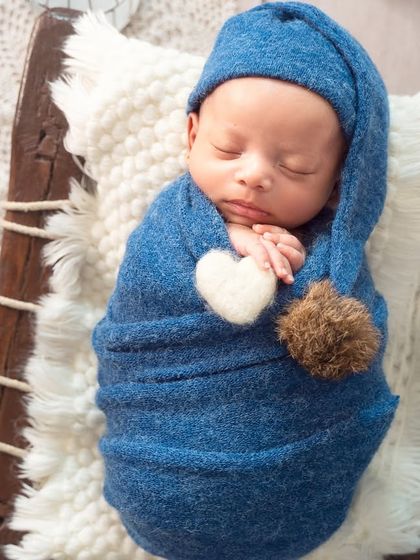 A close-up of the baby in a sleepy blue hat, swaddled snugly with a little heart accent. It's the small details that make a theme special.
