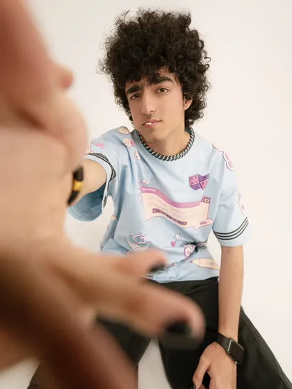 A creative, engaging shot for a streetwear brand, using hands in the foreground to frame the model. This adds a playful, interactive feel to the lookbook.