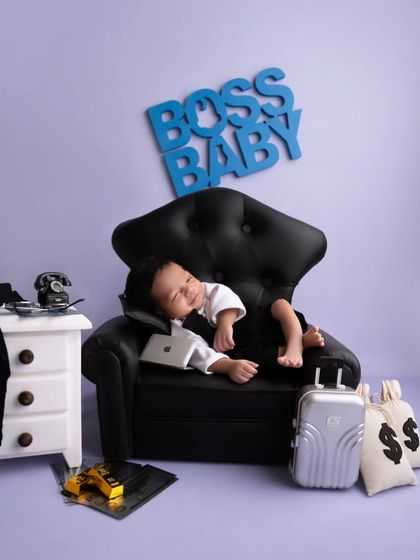 The Boss Baby taking a quick power nap with his mini laptop. A perfect shot for a modern and fun newborn announcement.