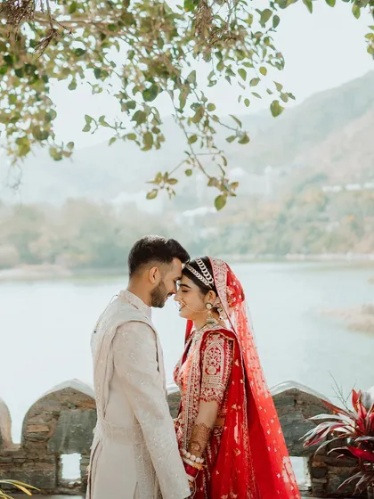 An intimate portrait of the couple by the lake, their foreheads touching. These serene moments provide a beautiful contrast to the high-energy celebrations.
