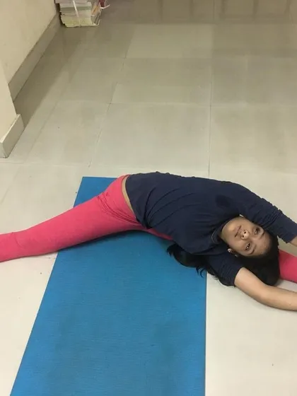 A young student in Parshva Upavistha Konasana, showing great flexibility.