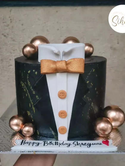 Suit up. A dapper tuxedo cake perfect for a gentleman's birthday. The black fondant cake is decorated with a shirt, bow tie, and bronze baubles for a touch of class.